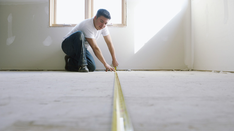 Man measuring floor with tape measure