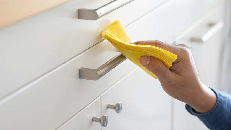 A hand wiping a drawer