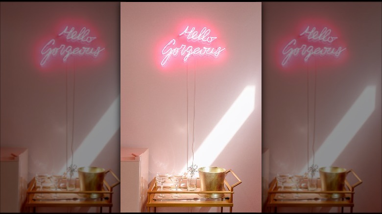 neon sign above bar cart