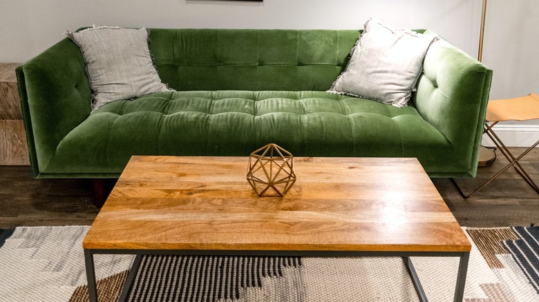 green velvet couch with table