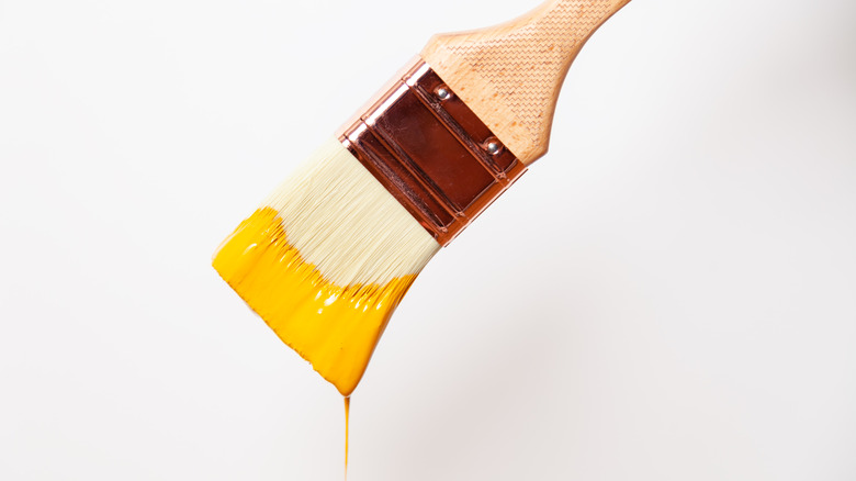 paintbrush dipped in yellow paint