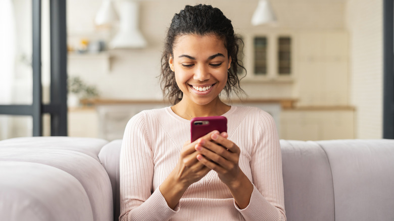 woman smiling at her cell phone