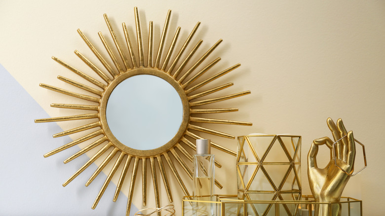 gold sunburst mirror on wall 