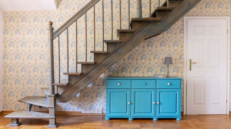 pink floral wallpaper behind staircase