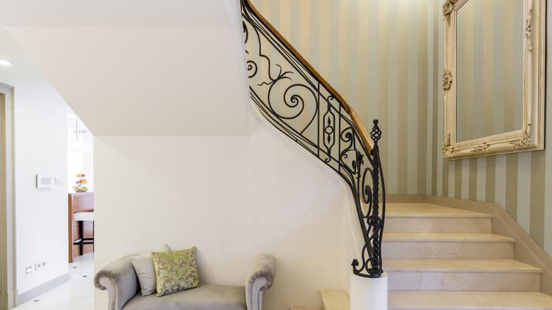 wallpapered staircase with wall mirror