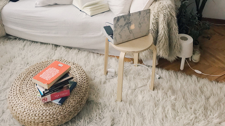 Stacked books on woven ottoman 