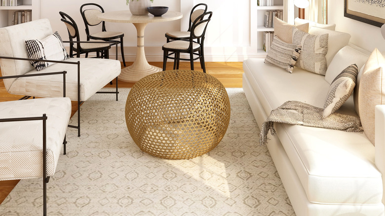 gold ottoman in white living room 