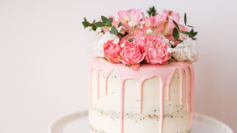 pink cake with flowers and greenery