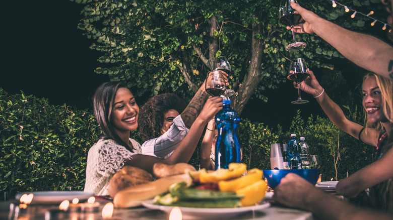 women with wine in backyard