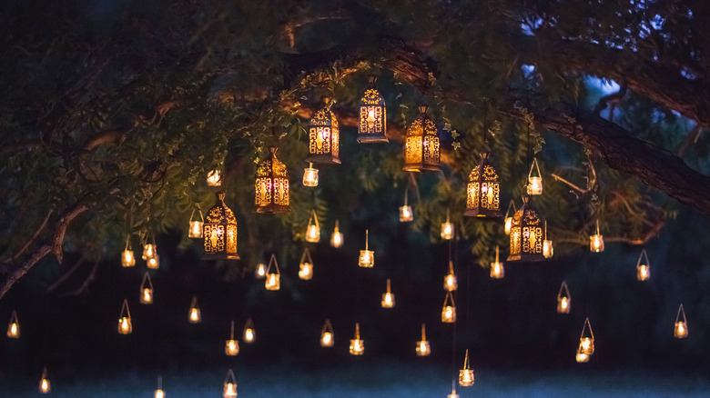 Lanterns filled with candles in branches