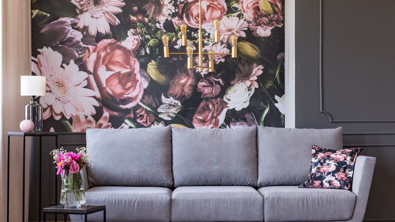 gray couch by floral wallpaper