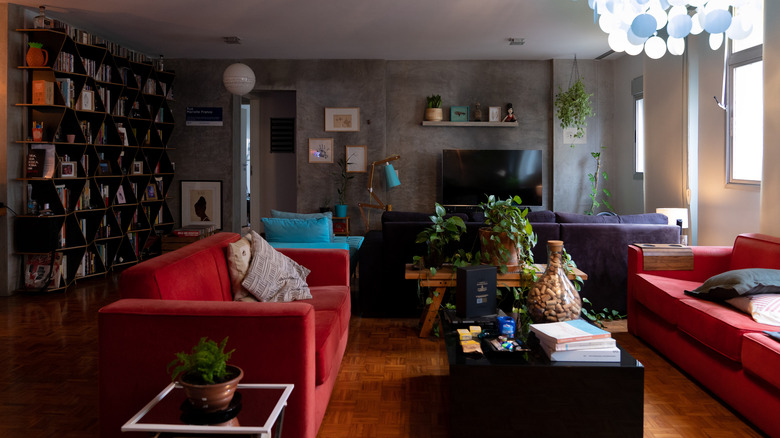 giant bookcase behind red couch