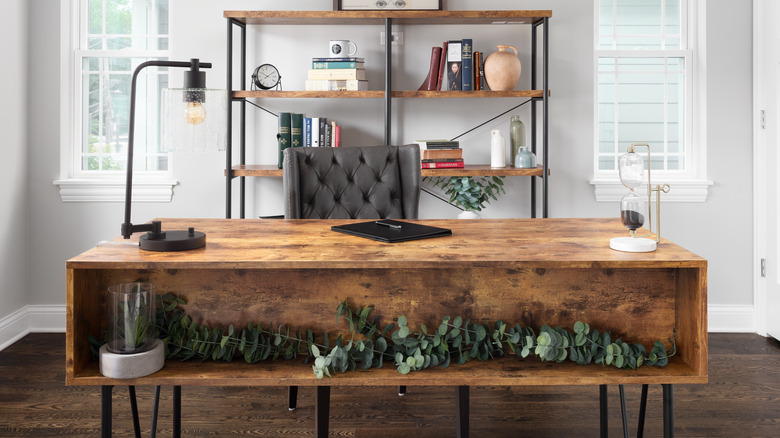 wrought-iron shelving unit behind a wooden desk