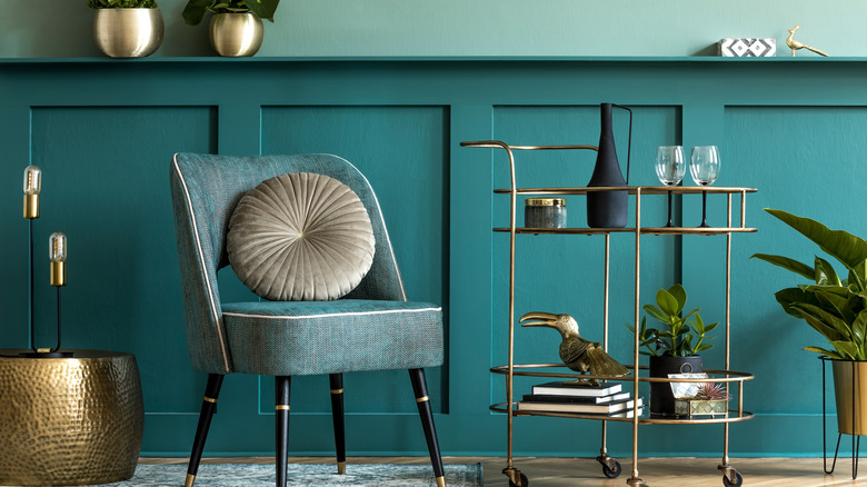 teal walls and gold bar cart