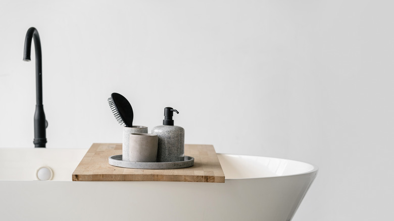 white bathtub with wooden tray 