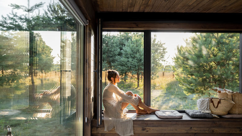 woman by window looking at yard