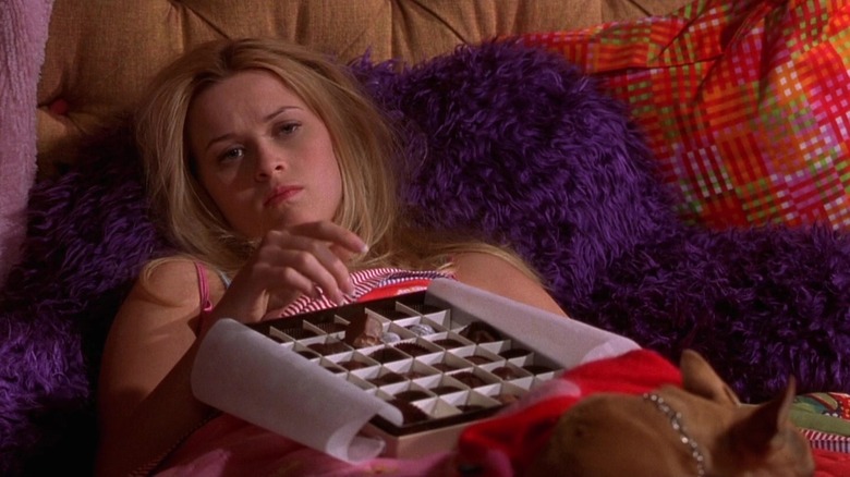 Elle sad in bed with chocolates