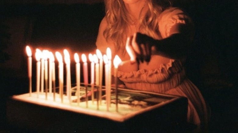 girl lighting candles in room