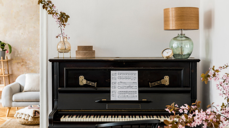 black piano with lamp and flowers 