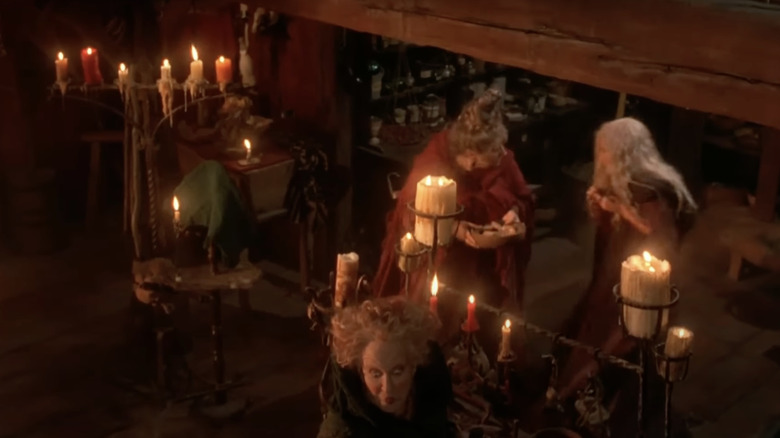 The Sanderson sisters are surrounded by candles, and wood and metal decor.