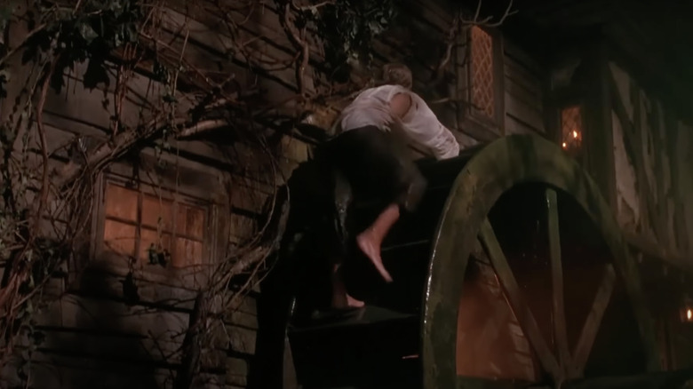 Thackery Binx climbs a water mill next to the Sanderson sisters' house.