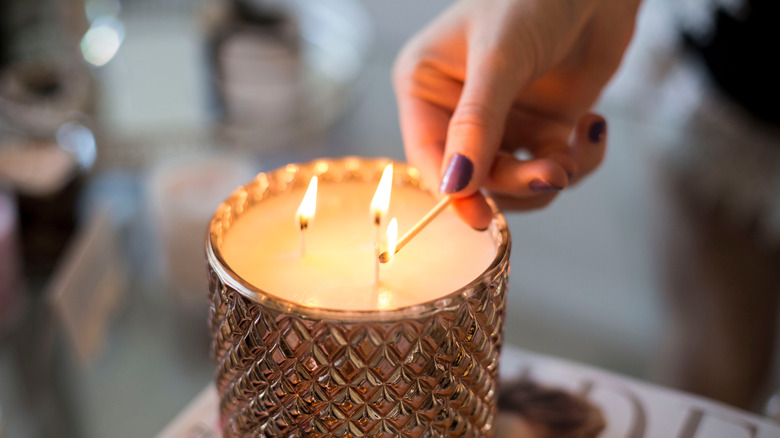 hand lighting candle with match