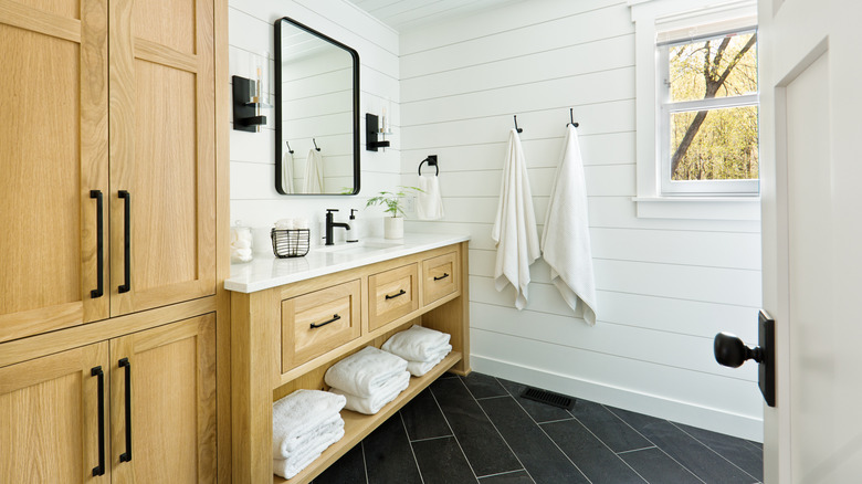 A white contemporary bathroom with a rustic cabinet