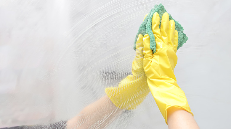 A person cleaning a mirror