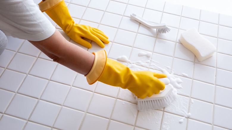 A person cleaning the bathroom floor