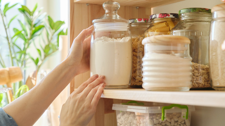 woman's hands grabbing glass jar