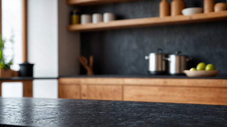 Black marble countertops with natural wood cabinets