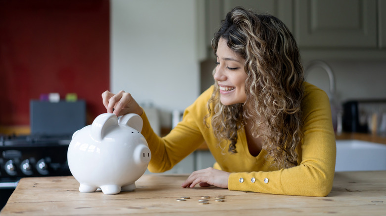 woman with piggy bank in kitchen