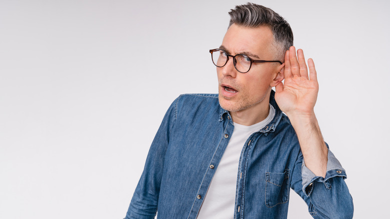 man cupping his ears