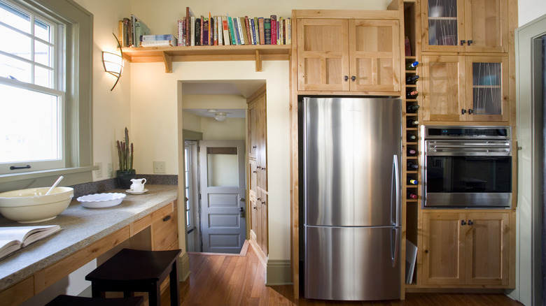 A refrigerator in cabinet surround with a cabinet above it