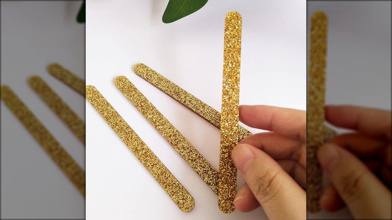 hand holding glittery popsicle stick