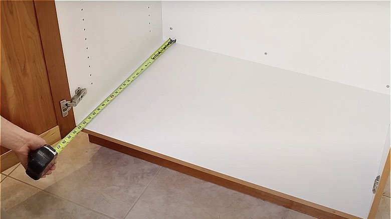 person measuring cabinet