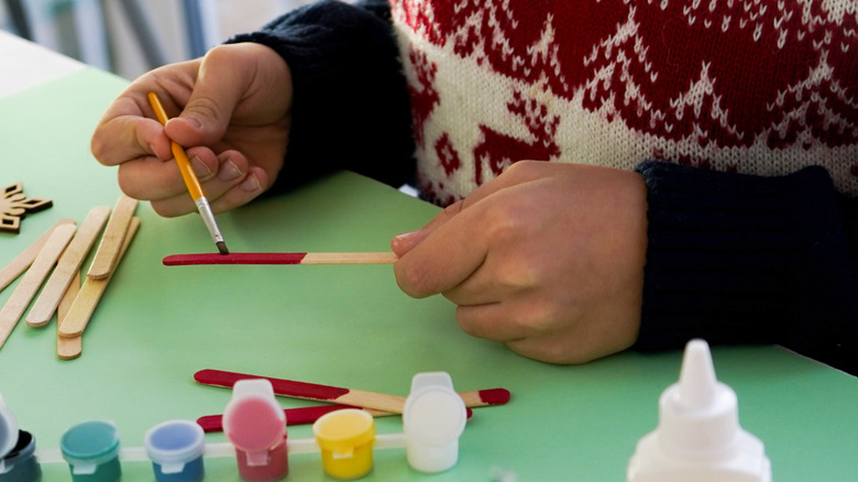 Hand painting craft stick with paintbrush