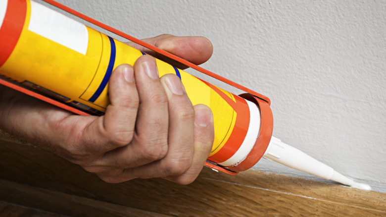 Close-up of caulking gun against trim