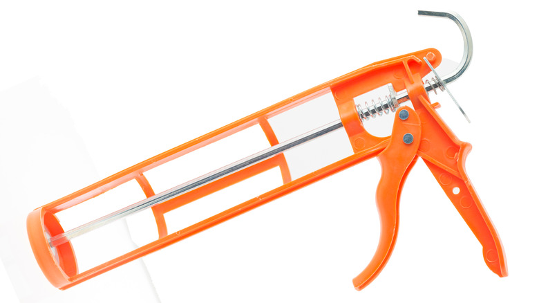 An orange manual caulking gun