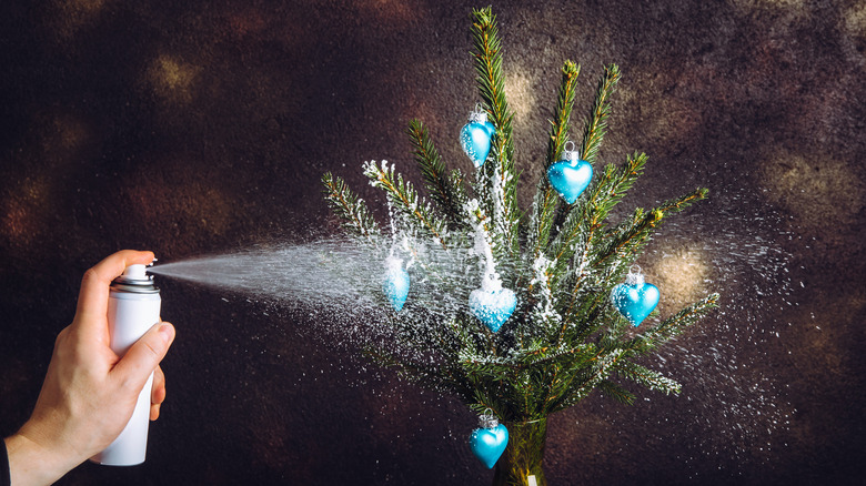 Person spraying flock on tree