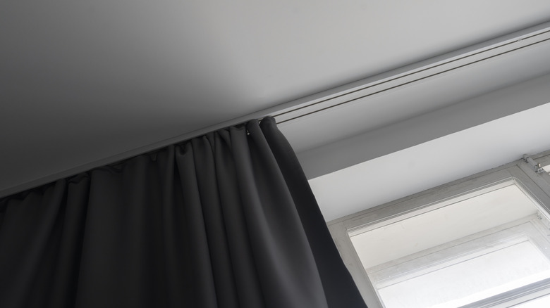 grey colored blackout curtains on white ceiling curtain tracks