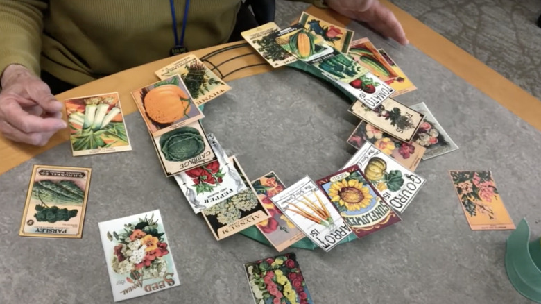 person arranging seed packets on wreath