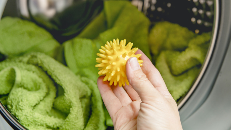 Person holding yellow dryer ball