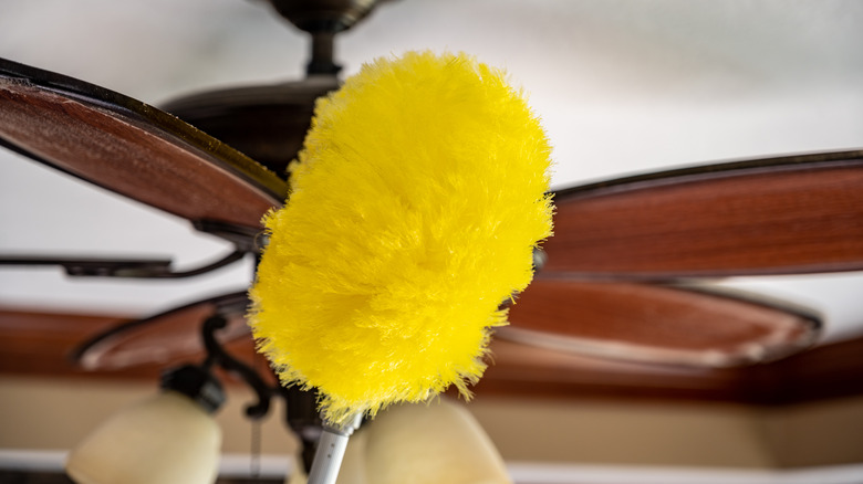 Feather duster wiping a ceiling fan