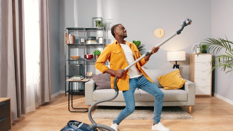 Happy guy with vacuum cleaner