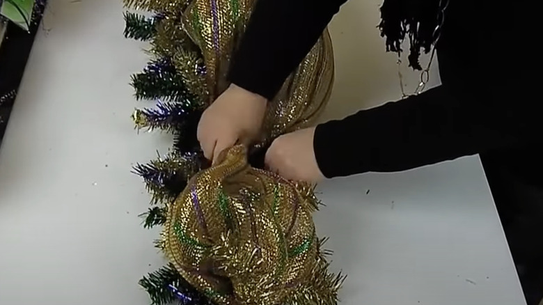 person making Mardi Gras garland