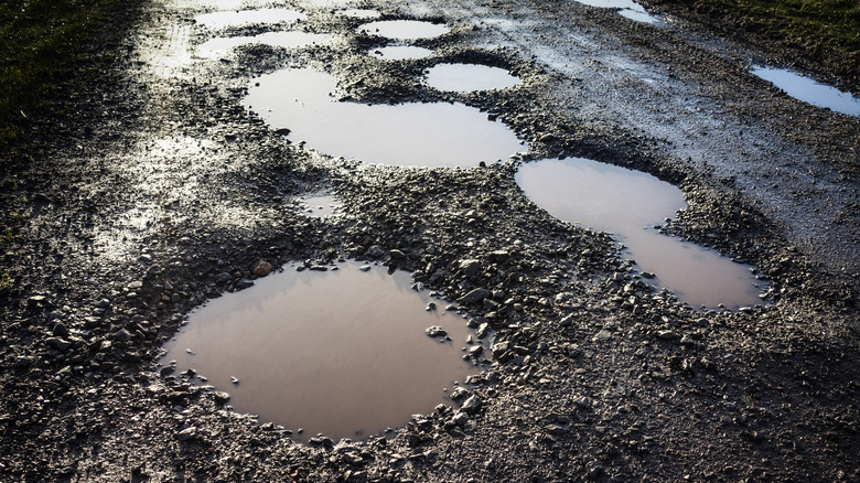 Potholes on a wet gravel road