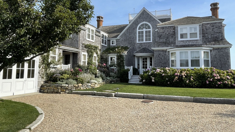 A smooth gravel driveway leading up to a gray house