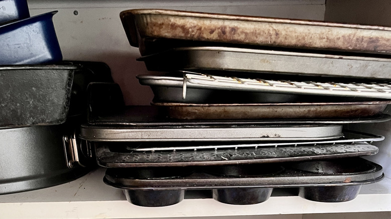 piles of bakeware in cabinet