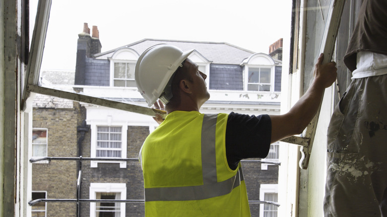 Men removing a window sash